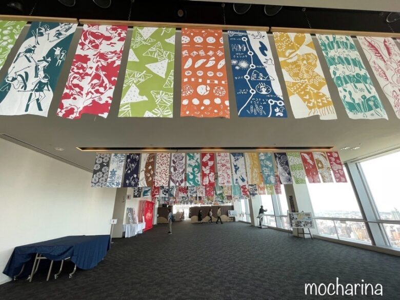 朱鷺メッセの展望コーナーの「手ぬぐい展示会」の写真。天井から色とりどりの手ぬぐいが吊るされた様子。
