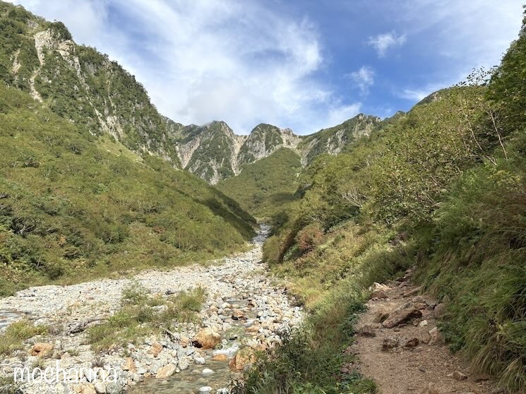 槍ヶ岳への沢沿いの登山道の写真。山並みと川が写った景色。