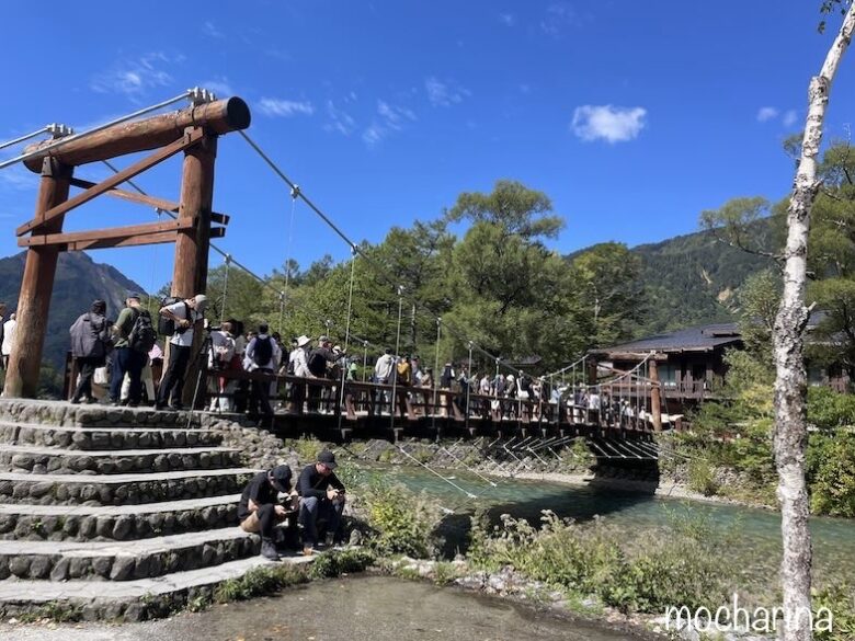 上高地の眼鏡橋の写真。たくさんの観光客が橋の上にいる様子。