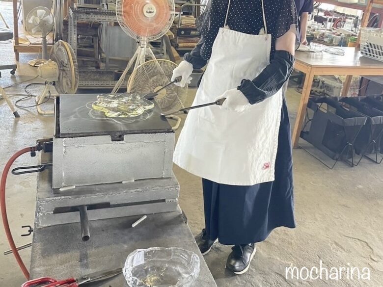 ガラスの皿を作っている写真。コテで雲型に整えている様子。